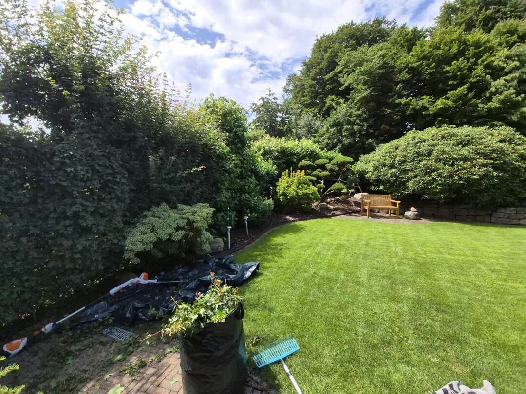 Garten mit Schnittgut und Werkzeug w&auml;hrend der laufenden Pflege