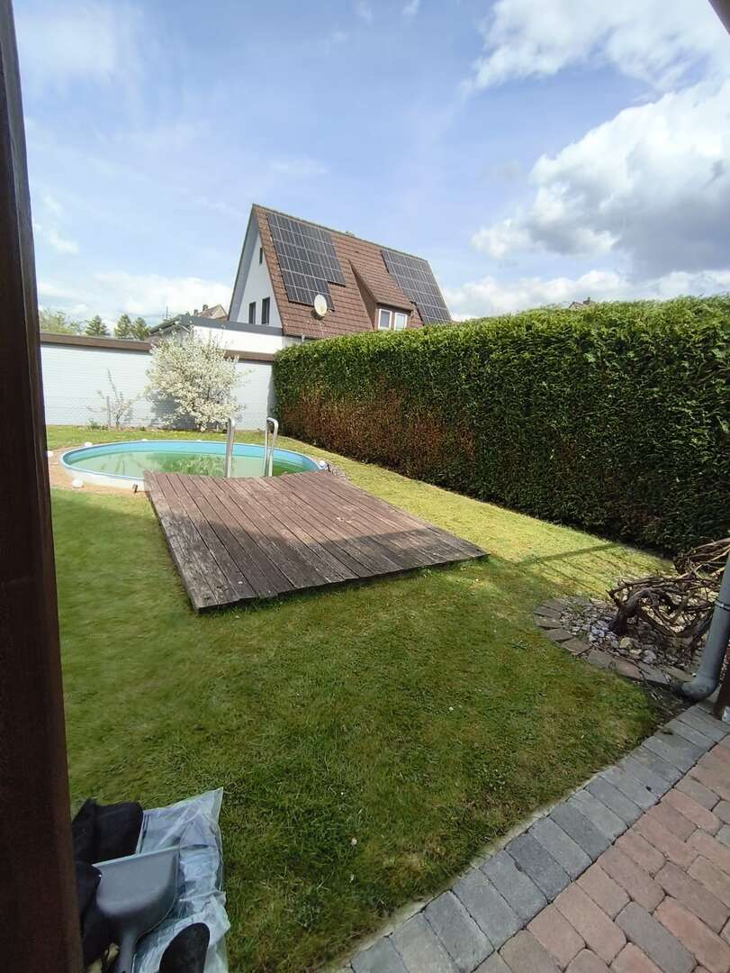 Gepflegter Rasen und geschnittene Hecke am Pool